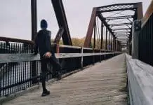 Mand strækker ud før han løber over bro