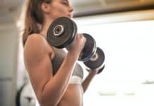 Kvinde løfter vægte i fitness center