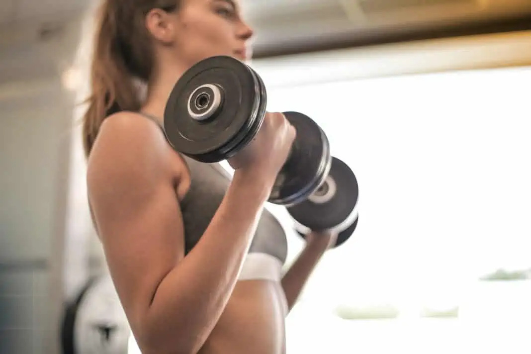 Kvinde løfter vægte i fitness center